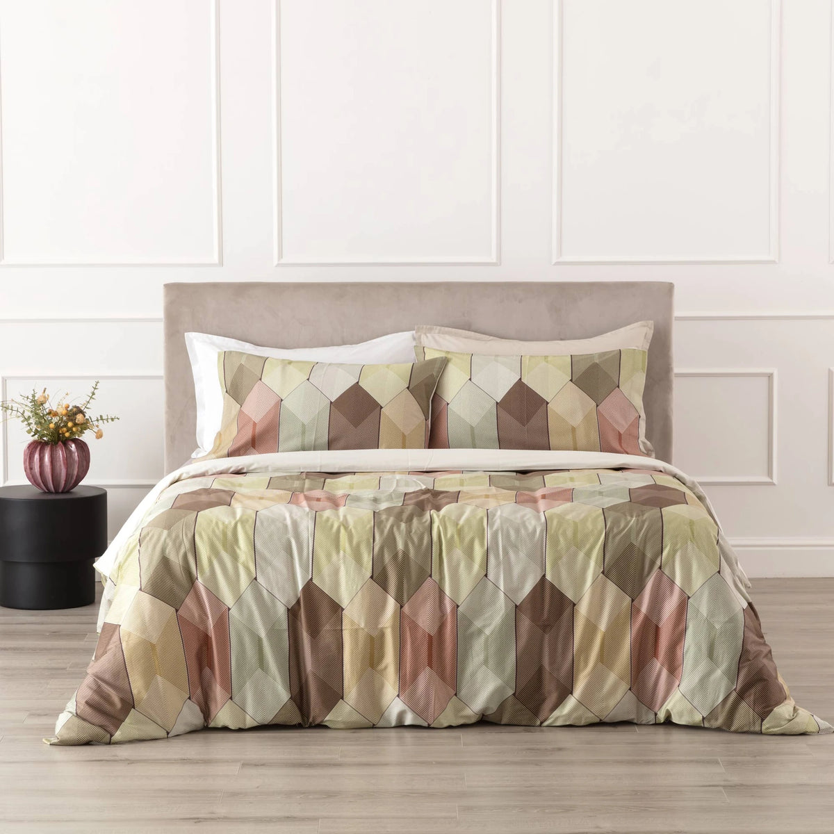 Fantasia Diamante Reevèr in raso di cotone con fantasia geometrica multicolore, ambientata sul letto.