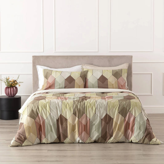 Fantasia Diamante Reevèr in raso di cotone con fantasia geometrica multicolore, ambientata sul letto.