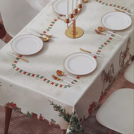 Tovaglia Christmas Neith su tavola apparecchiata con cavallini, trenini e decorazioni natalizie