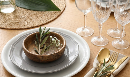 Tavola elegante apparecchiata secondo il galateo con tovaglia, piatti e posate disposte correttamente