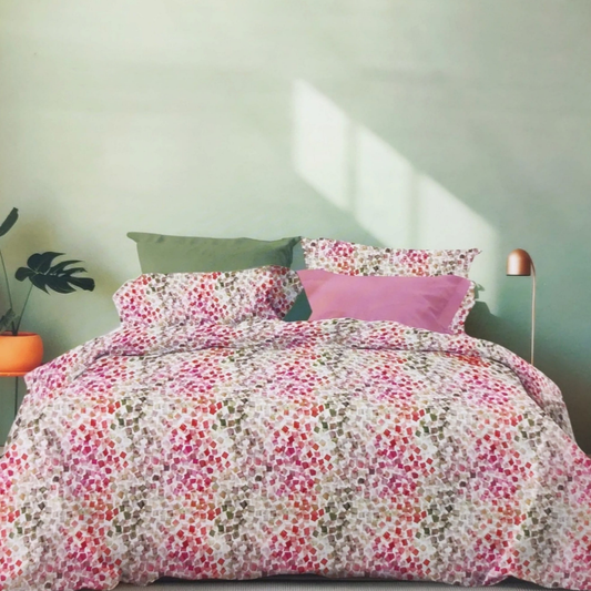 Completo lenzuola matrimoniale Folata Tag House rosa effetto copriletto con fantasia geometrica multicolore ambientato sul letto