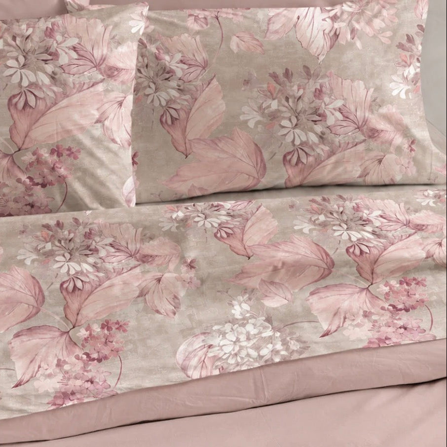 Completo lenzuola matrimoniale Perla rosa in cotone stampato con fiori, fotografato sul letto