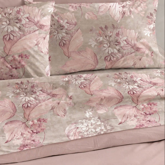 Completo lenzuola matrimoniale Perla rosa in cotone stampato con fiori, fotografato sul letto