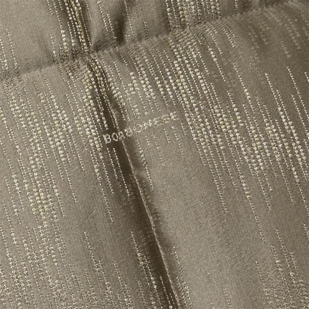Dettaglio del tessuto jacquard della trapunta Borbonese Micropaillettes Legno con logo tinto in filo.