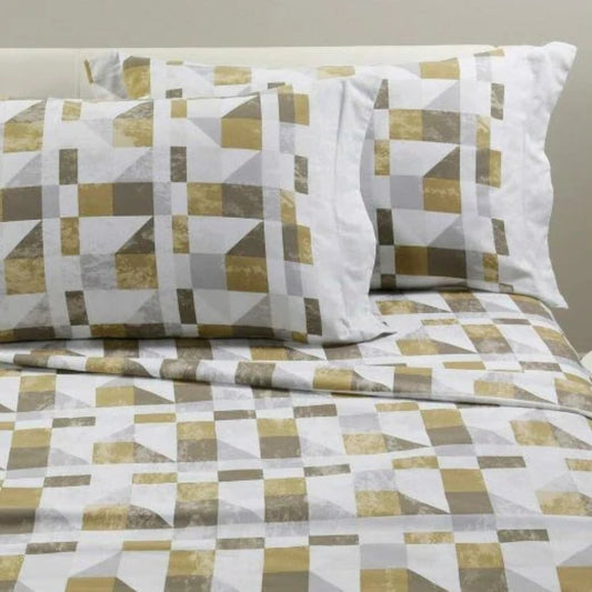 Completo lenzuola Cromatic Caleffi in flanella Oro ambientato su letto con fantasia a blocchi geometrici.