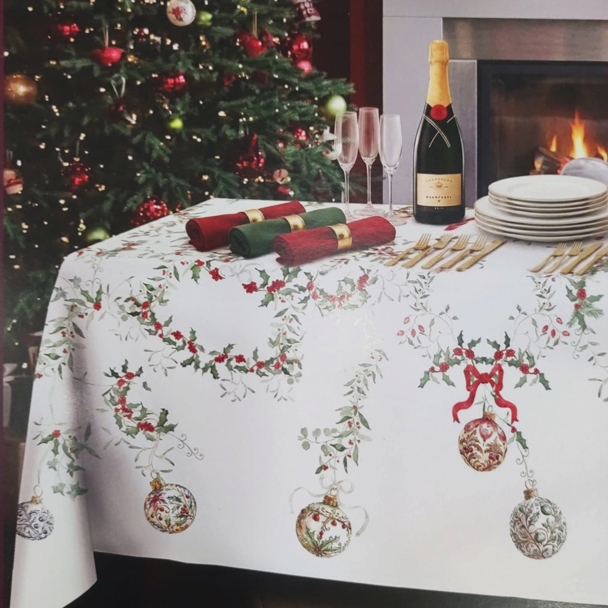 Tavola di Natale apparecchiata con tovaglia Christmas Eve Tessitura Randi, sfere decorative, agrifoglio e dettagli natalizi.