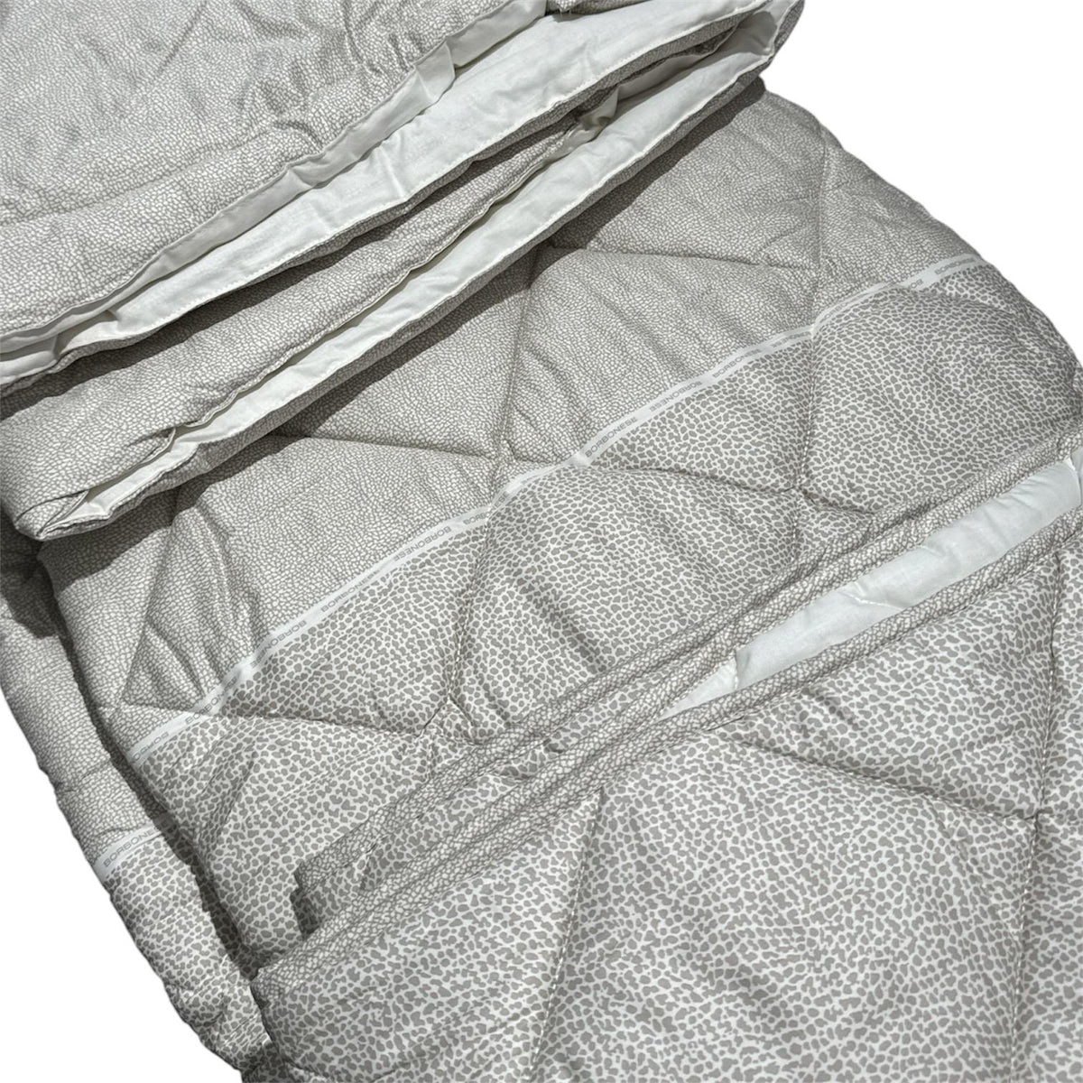 Trapunta Borbonese Century piegata, con fascia decorativa e logo Borbonese ripetuto