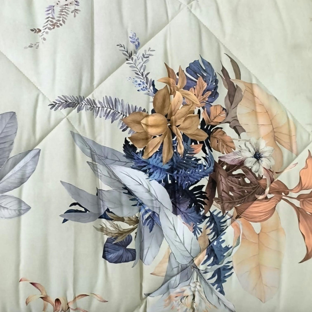 Dettaglio della trapunta DEA IF.23 in rasatello con fiori e foglie colorate e trapuntatura a rombi.