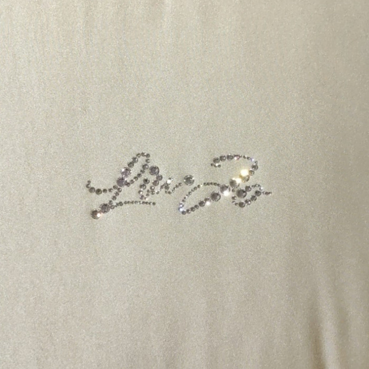 Dettaglio del logo Liu Jo con applicazioni in strass sulla trapunta Satin LL3218