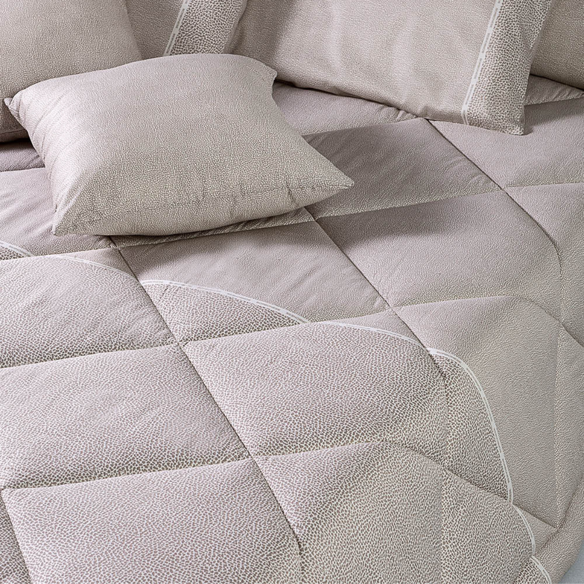 Trapunta matrimoniale Borbonese Century sul letto, con motivo Occhio di Pernice e fascia decorativa