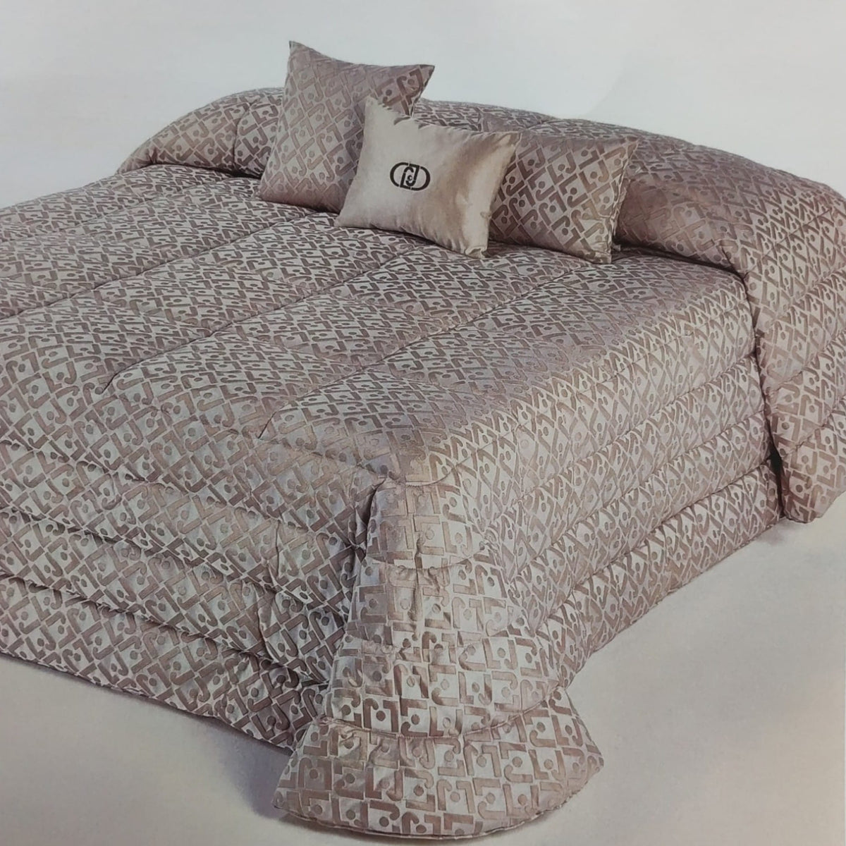 Trapunta matrimoniale Liu Jo New con monogramma LJ ambientata sul letto con cuscini coordinati