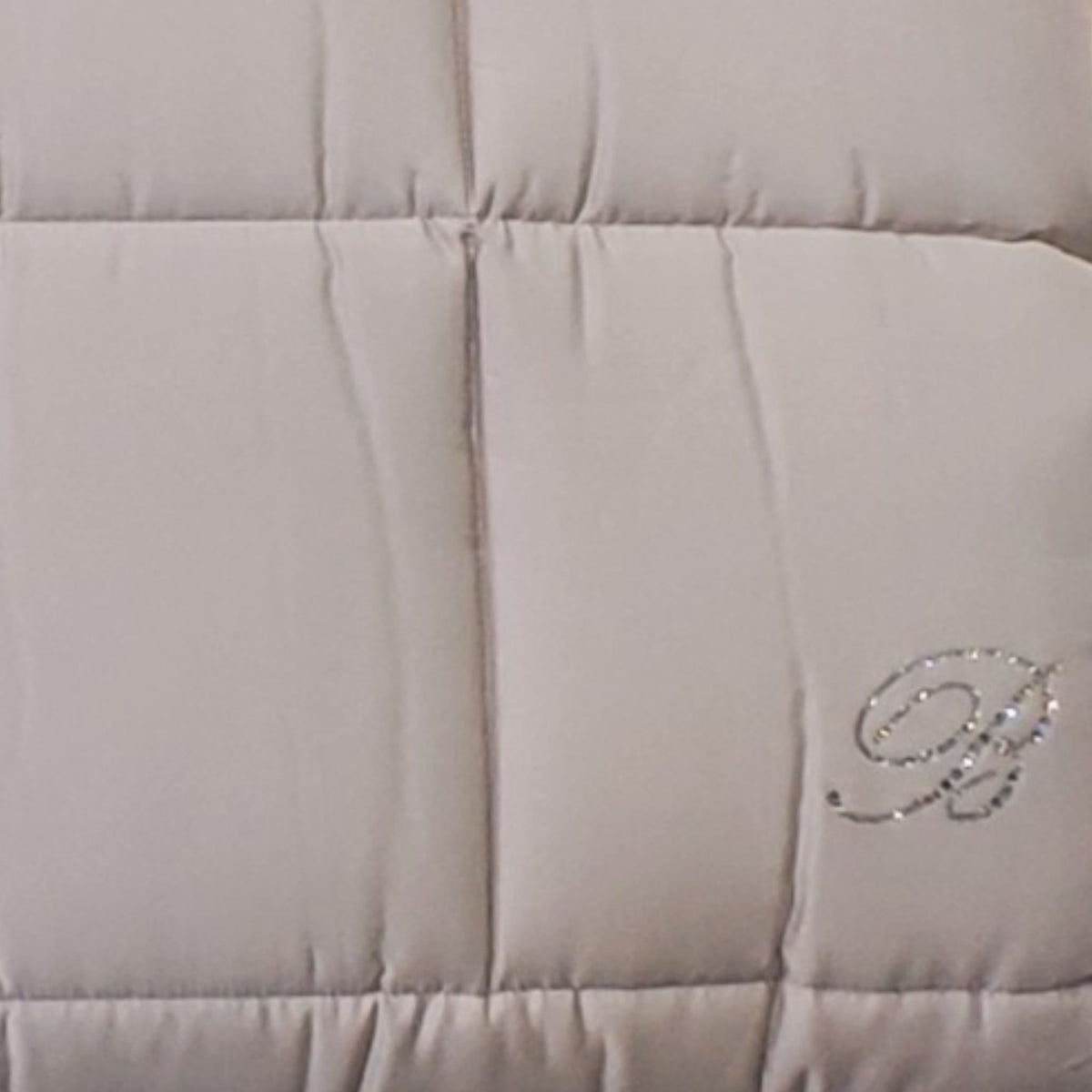 Dettaglio del monogramma B in cristalli sulla trapunta Samira Blumarine Home