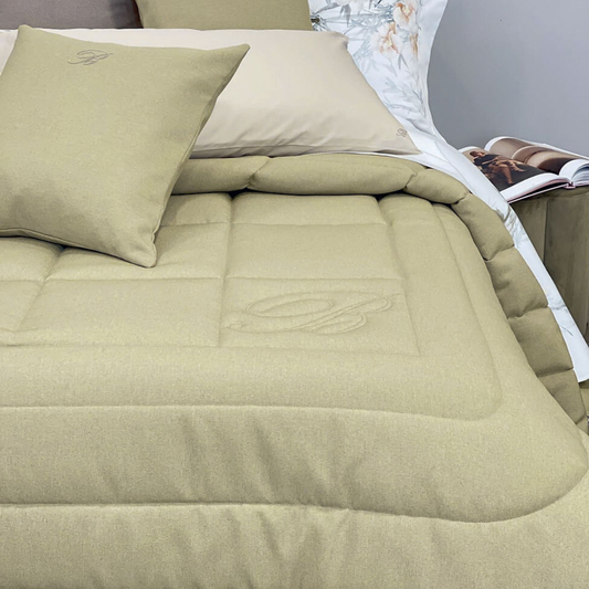 Trapunta matrimoniale Sunday Blumarine Home sul letto, con cornici trapuntate e logo B tono su tono