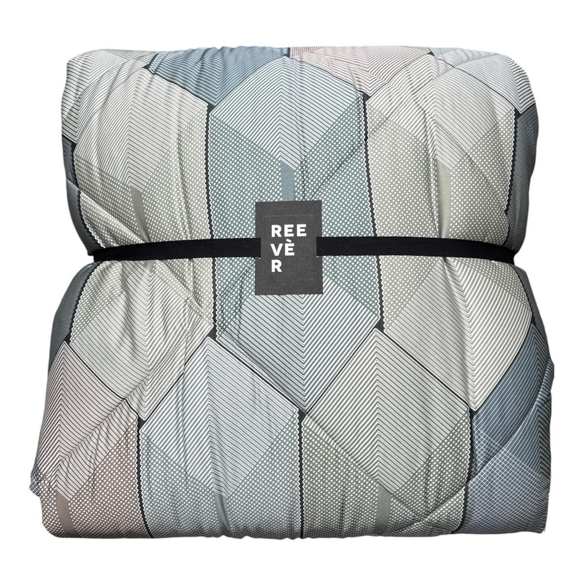 Trapunta Reevèr Diamante con stampa geometrica sui toni beige, rosa antico e verde salvia, fotografata in camera da letto.