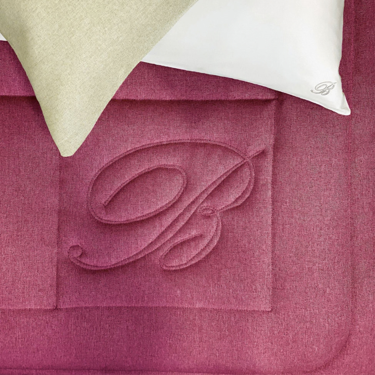 Dettaglio della trapunta Sunday Blumarine Home Borgogna con logo B realizzato in trapuntatura