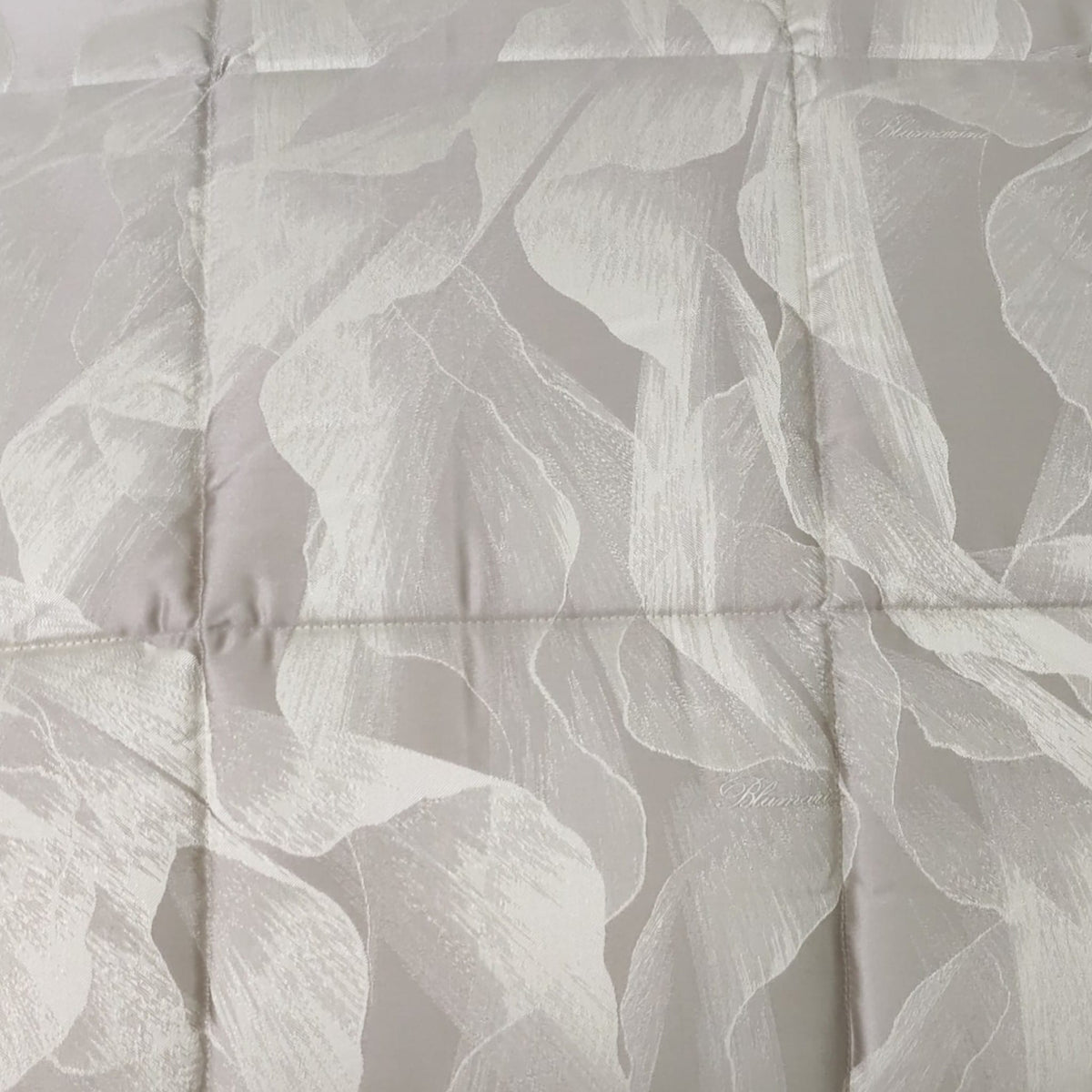 Trapunta Vera Blumarine Home Beige ripiegata, con disegno botanico jacquard e trapuntatura a riquadri